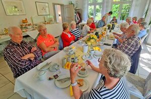 Viele Personen an einem langen, gedeckten Tisch